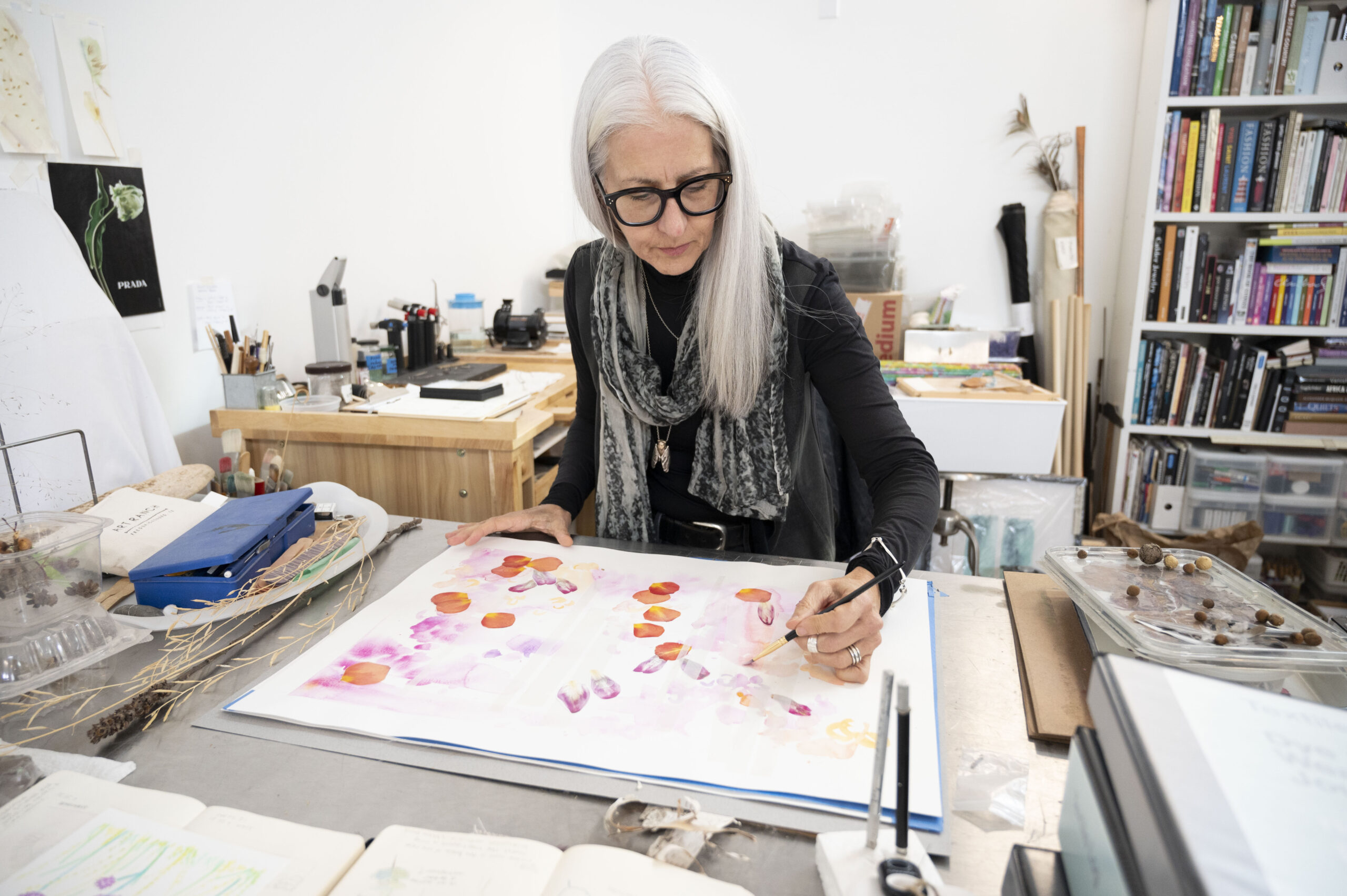 Amy Tucker in her studio using natural dyes to paint a pattern on a white sheet